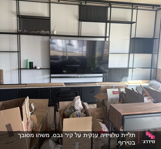 מדפים עם טלוויזיה וארגזים בחדר מגורים